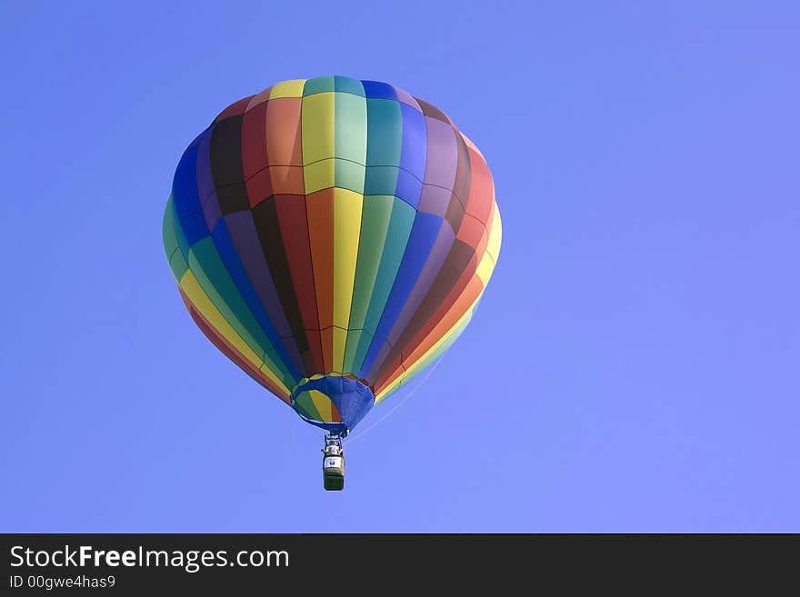 A hot air balloon gently lifts off the ground and floats above the treetops. A hot air balloon gently lifts off the ground and floats above the treetops