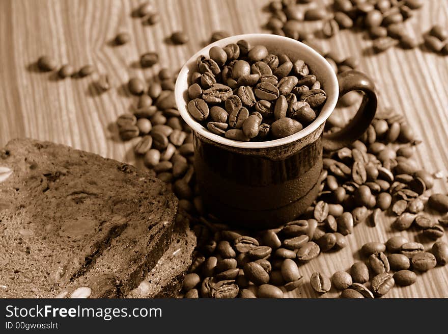 Coffee beans and rye toast on tabletop. Coffee beans and rye toast on tabletop