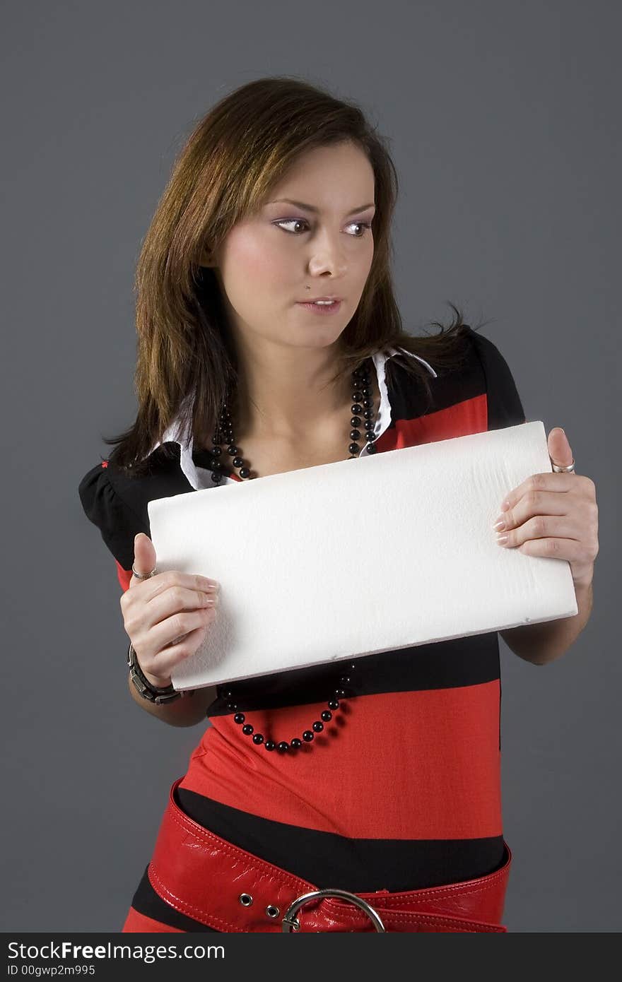 Attractive brunette wearing a red and black dress holding a white sign. Attractive brunette wearing a red and black dress holding a white sign