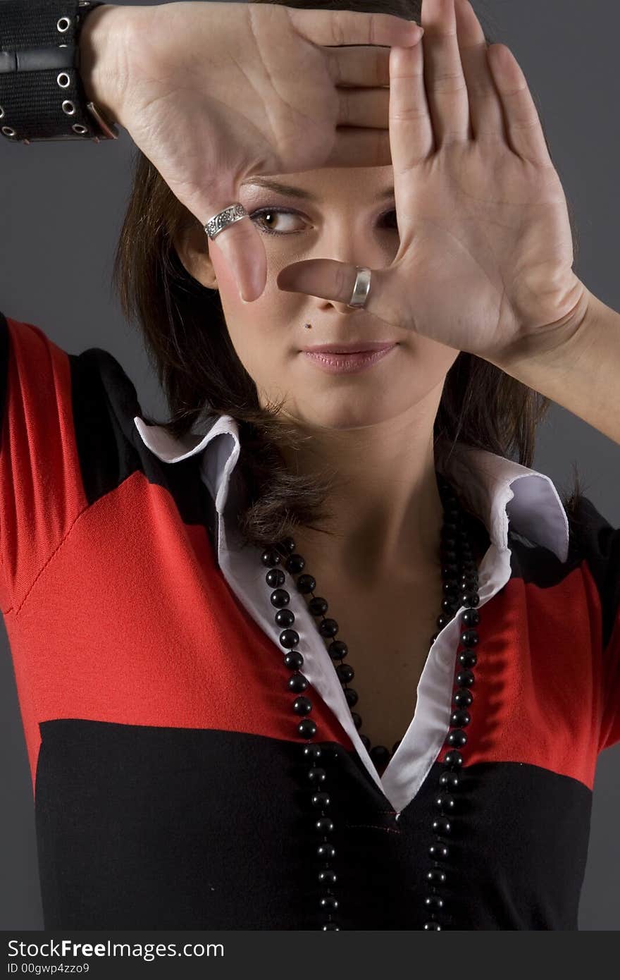 Attractive brunette wearing a red and black dress creating square with hands. Attractive brunette wearing a red and black dress creating square with hands