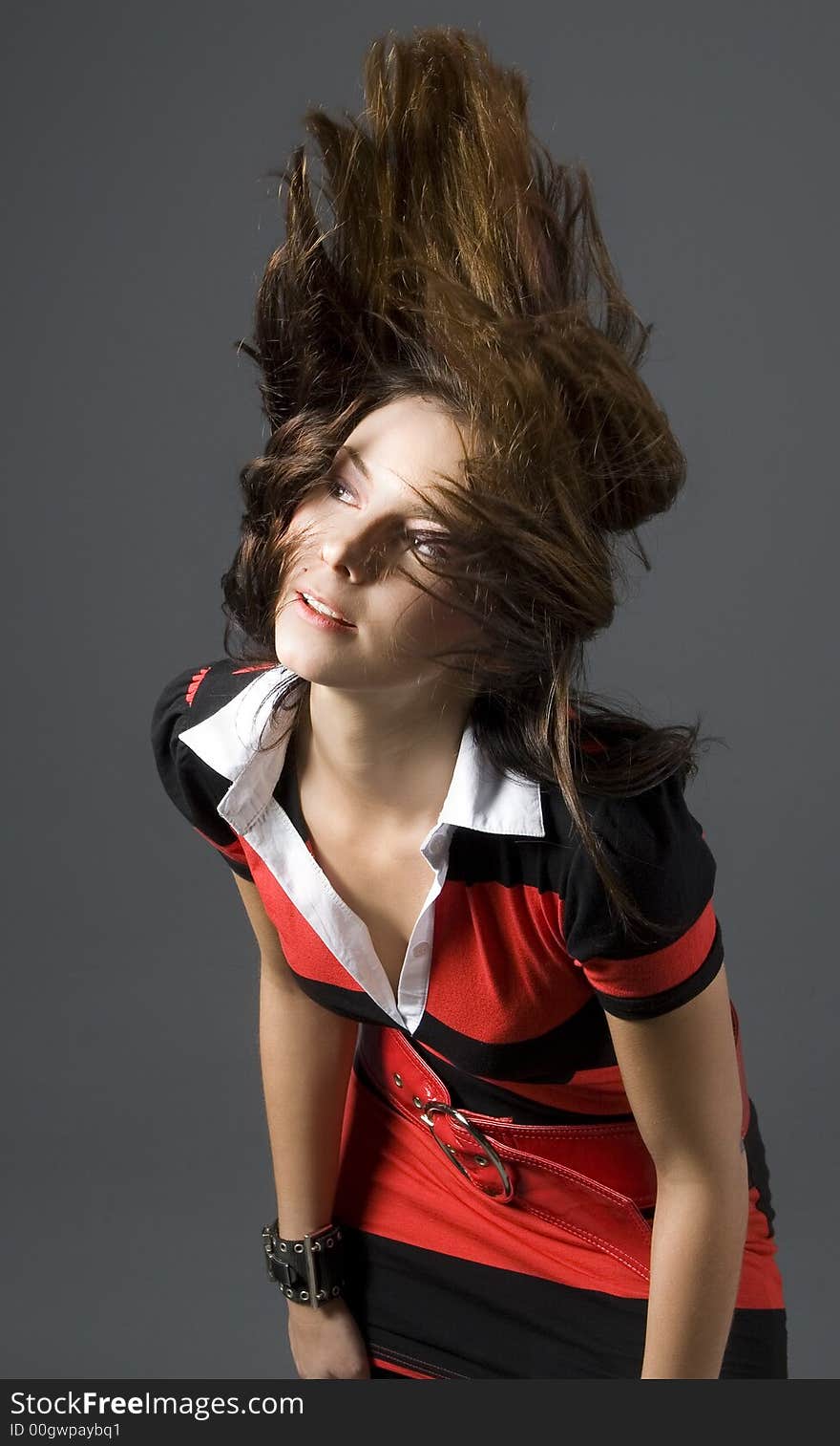 Attractive brunette wearing a red and black dress throwing hair back. Attractive brunette wearing a red and black dress throwing hair back