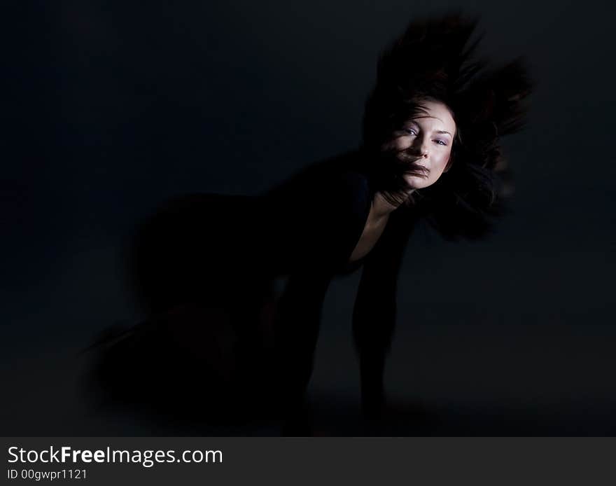 Attractive brunette on her knees wearing a black dress throwing hair back. Attractive brunette on her knees wearing a black dress throwing hair back