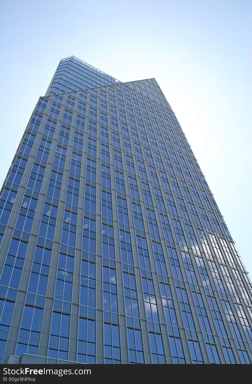 Blue glass building rising into sky. Blue glass building rising into sky