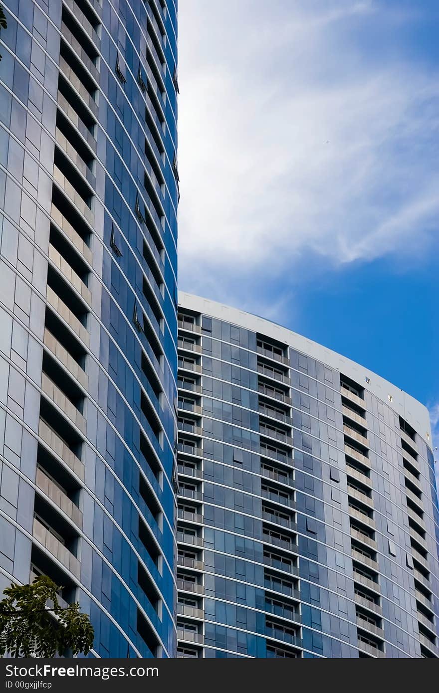 Twin skyscraper towers reflecting the blue sky colors