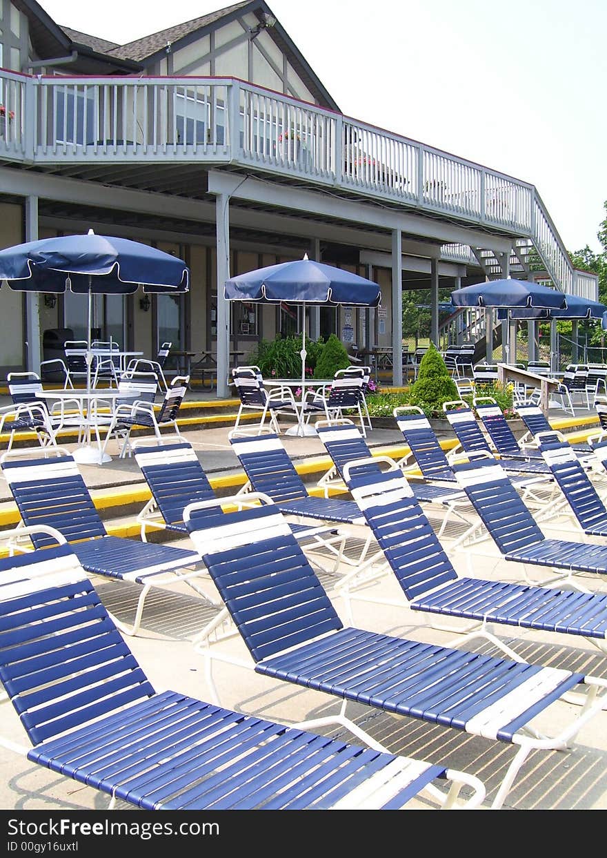 Outdoor swimming pool in the resort with long chair and sun umbrellas. Outdoor swimming pool in the resort with long chair and sun umbrellas