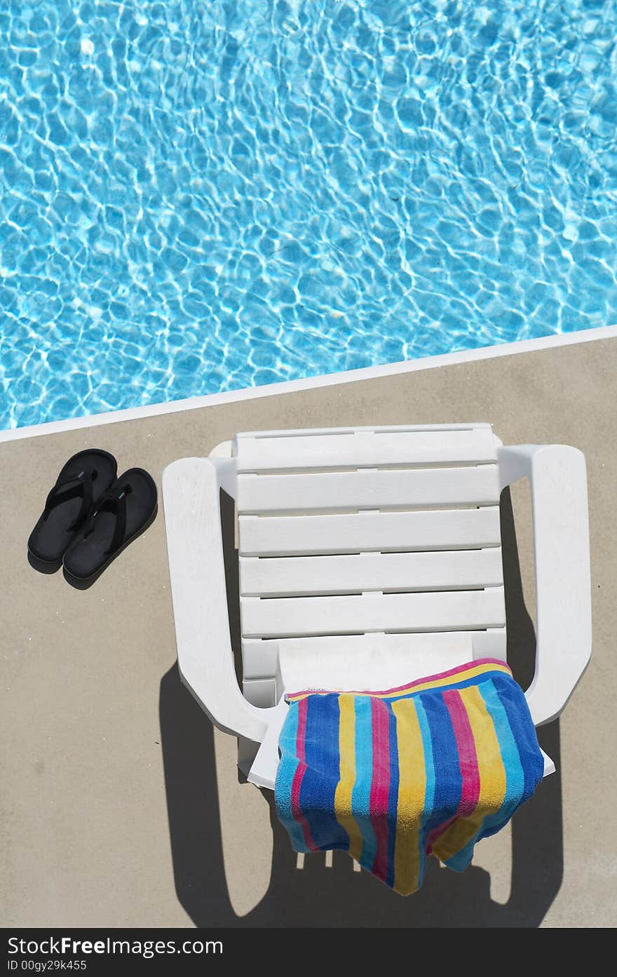 Chair, towel, and flipflops by the pool. Chair, towel, and flipflops by the pool