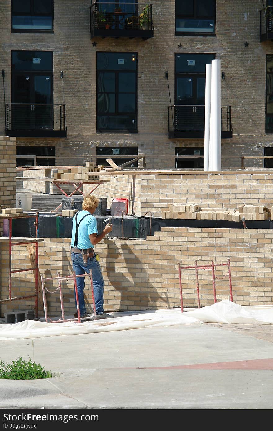 A picture of a construction worker working to build a building. A picture of a construction worker working to build a building