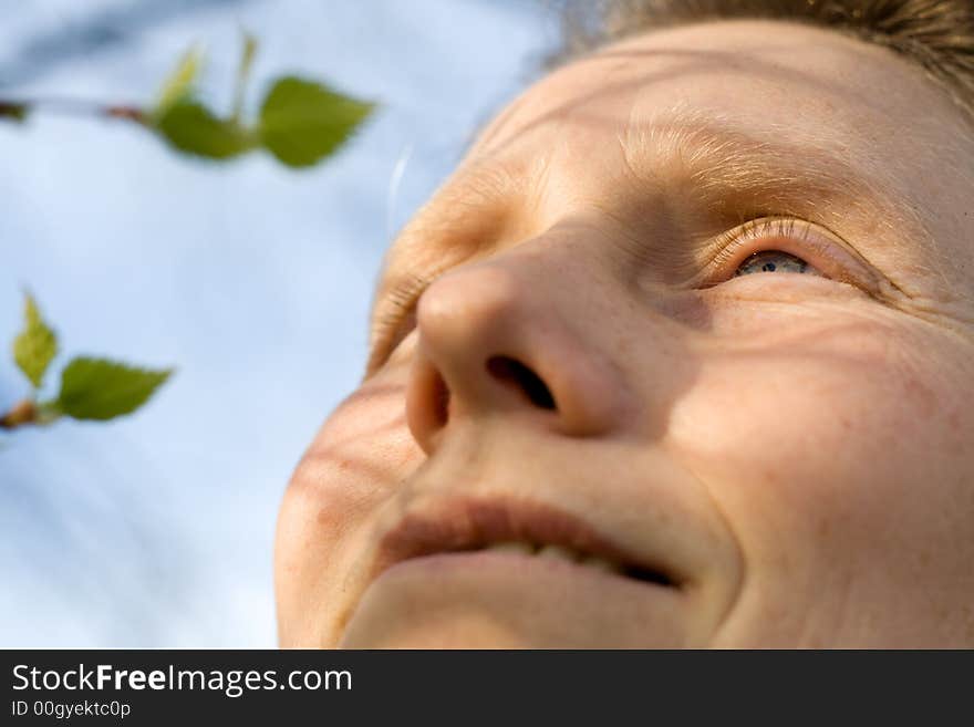 Woman and branch of birch tree with leaves is expanding. Woman and branch of birch tree with leaves is expanding