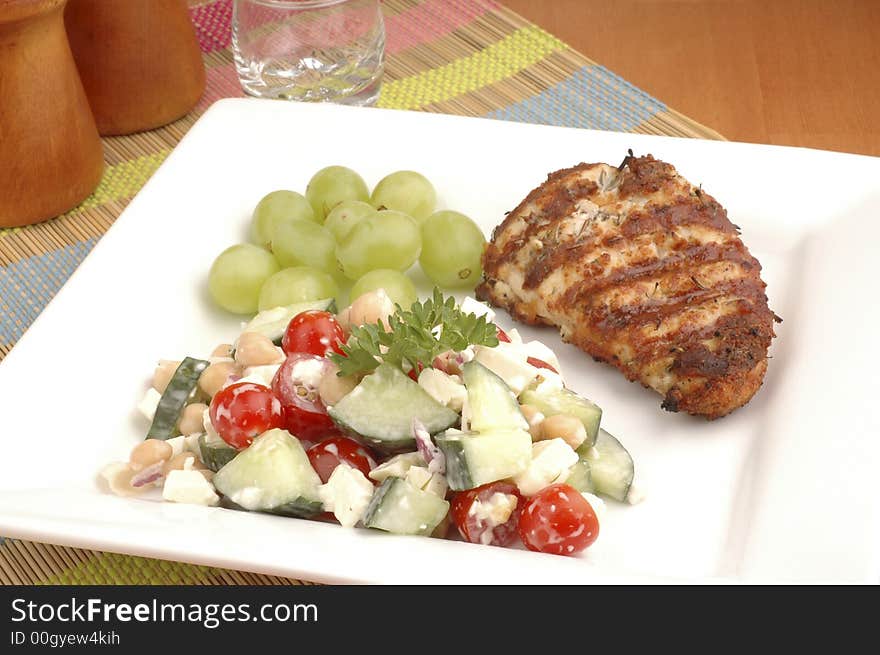 Summer salad served with grilled chicken and grapes.