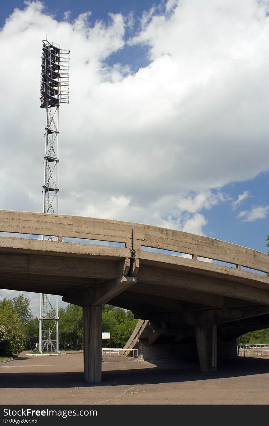 Stadium searchlirht and road on blue sky with clouds