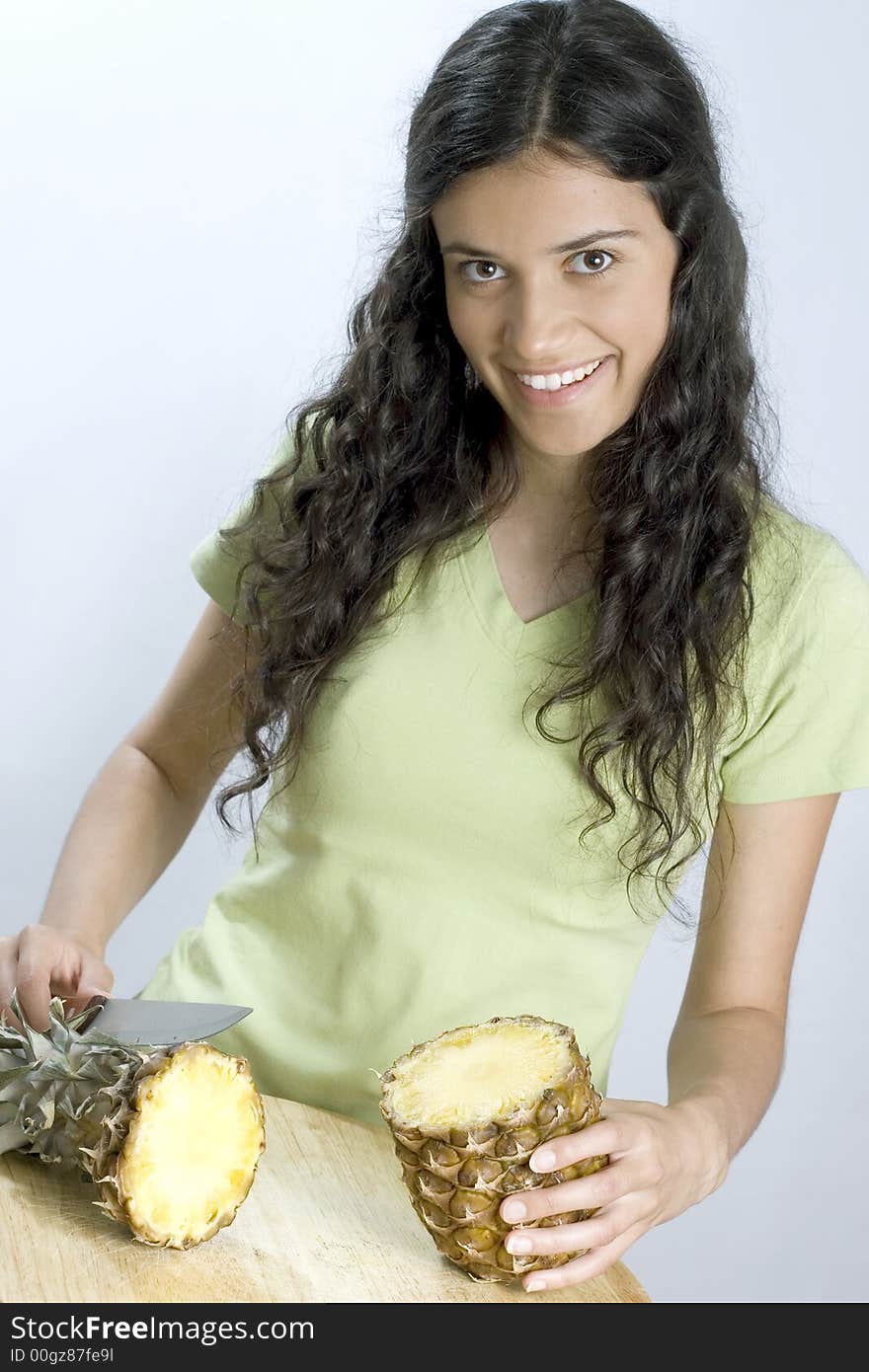 Smiling girl is cutting pineapple. Smiling girl is cutting pineapple