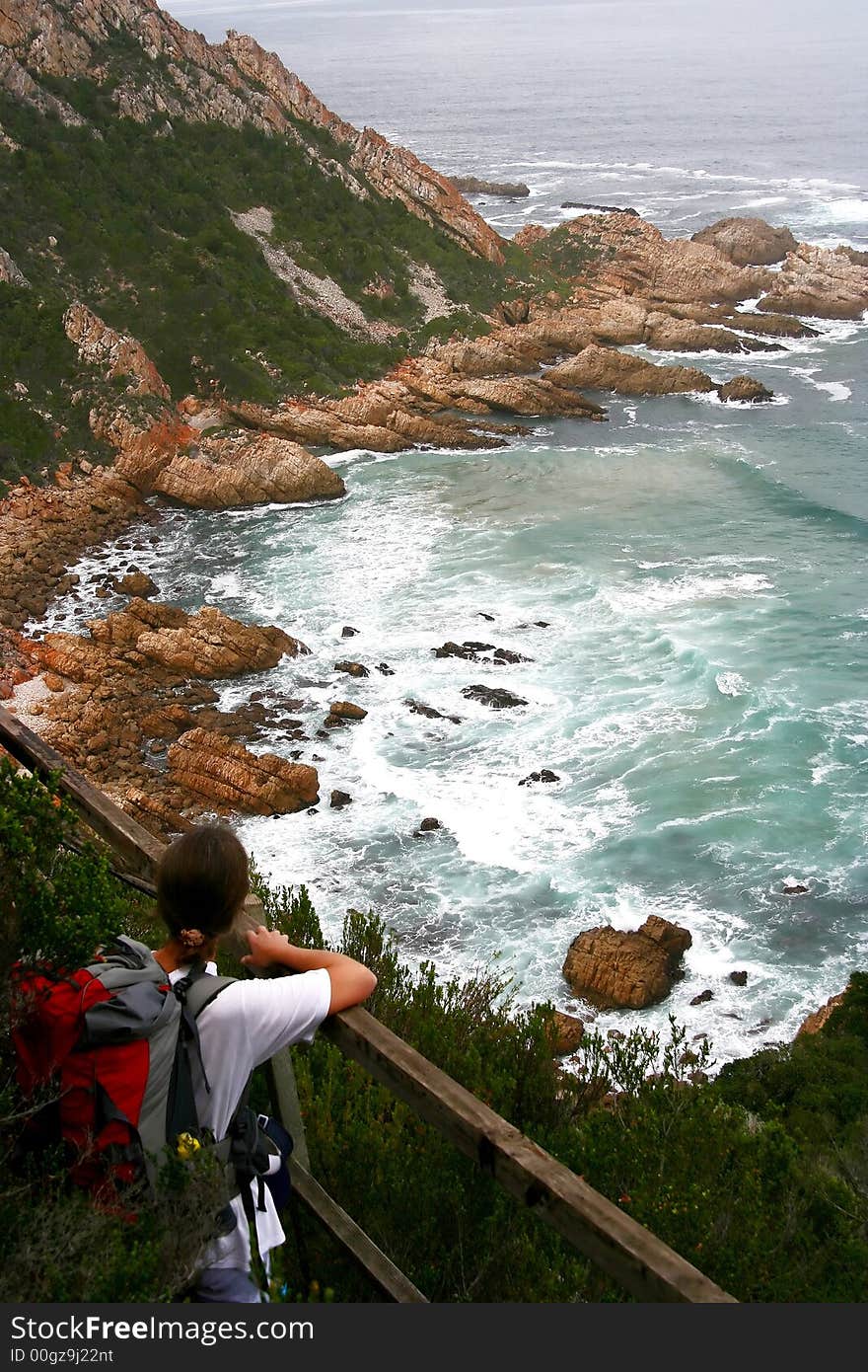 A hiker looking out across the ocean and enjoying the splendid view. A hiker looking out across the ocean and enjoying the splendid view