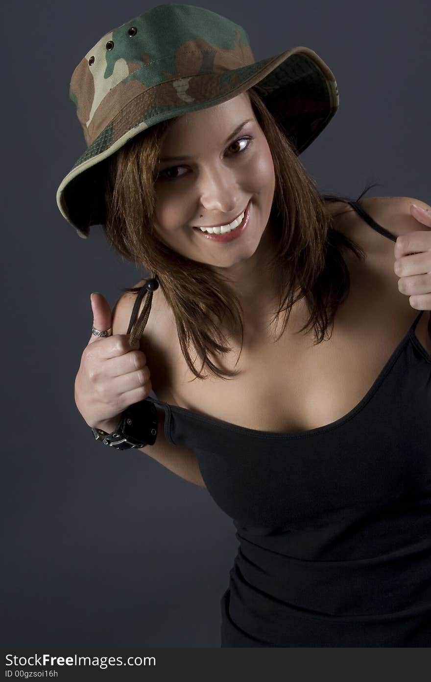 Attractive brunette military girl with a camouflage hat and black shirt. Attractive brunette military girl with a camouflage hat and black shirt