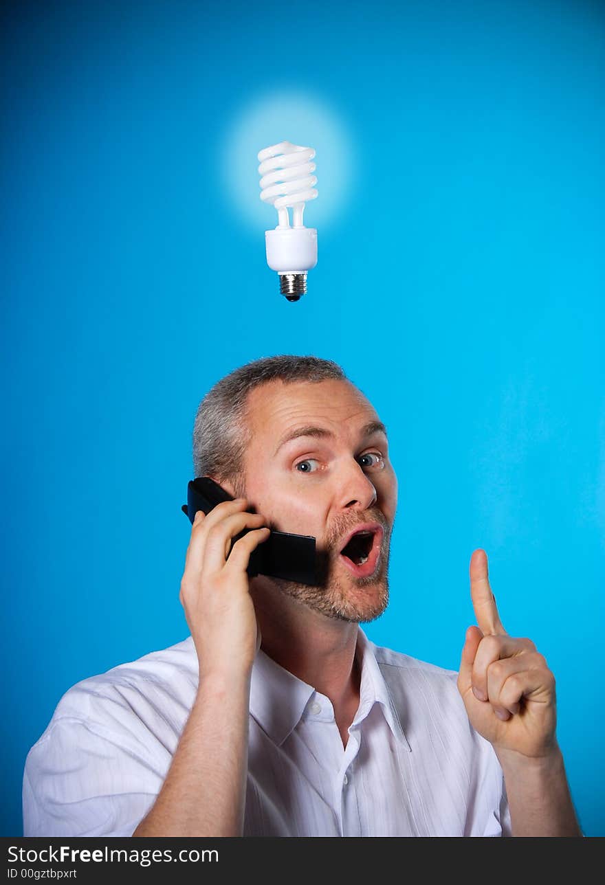 Man wih a beard with a light bulb on the phone. Man wih a beard with a light bulb on the phone