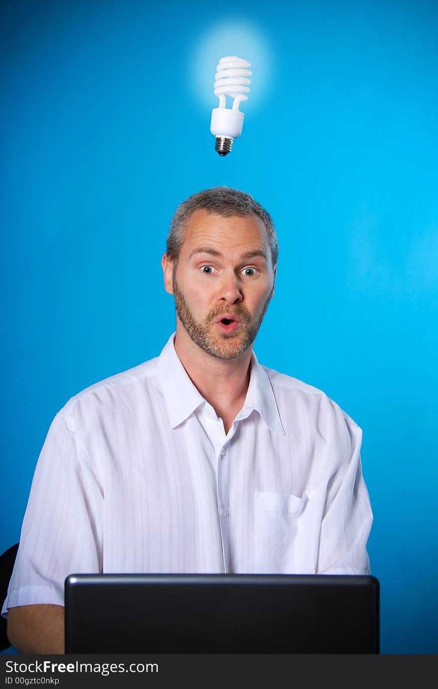 Man with a beard with a light bulb on the laptop. Man with a beard with a light bulb on the laptop