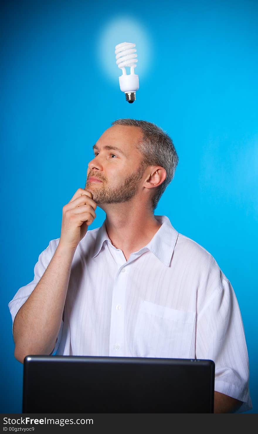 Man with a beard with a light bulb on the laptop. Man with a beard with a light bulb on the laptop