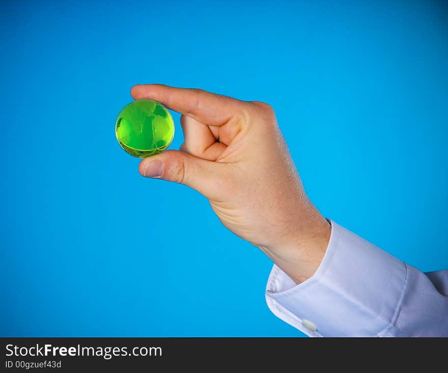 A hand with a small glass planet. A hand with a small glass planet