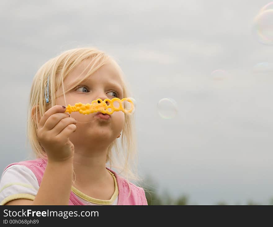 Young girl blowing soap bubbles. Young girl blowing soap bubbles