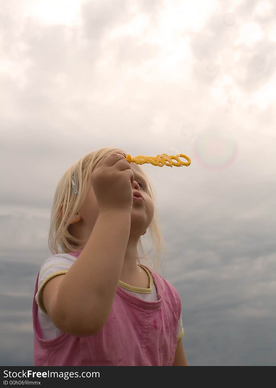 Young girl blowing soap bubbles. Young girl blowing soap bubbles