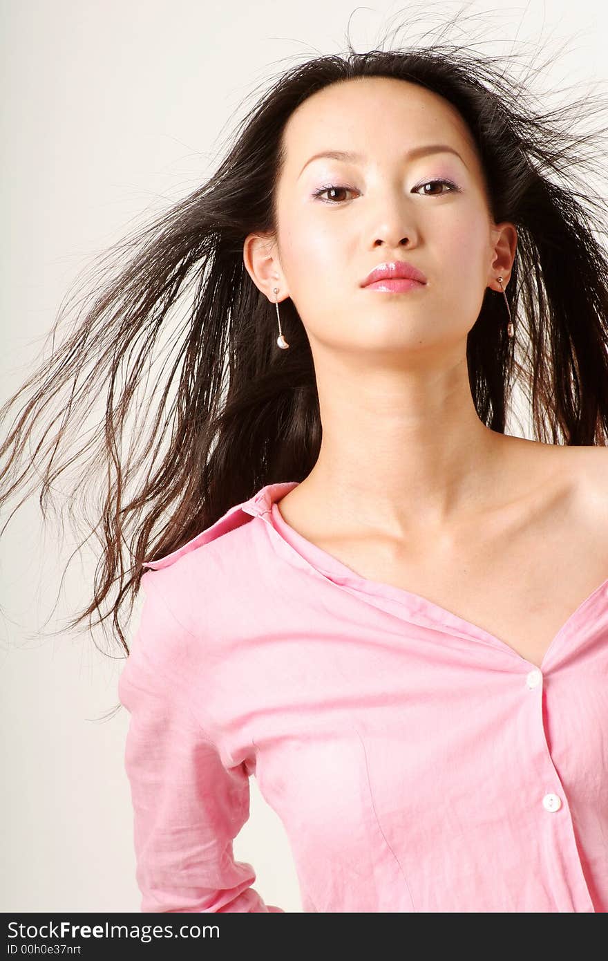 Enticing Chinese girl with flying hair in pink shirt