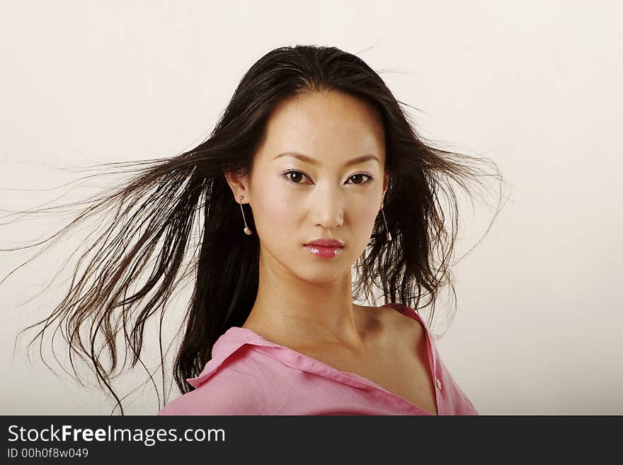 Enticing Chinese girl with flying hair in pink shirt