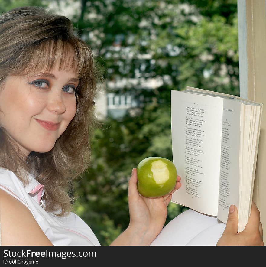 The woman reads the book and eats an apple. The woman reads the book and eats an apple