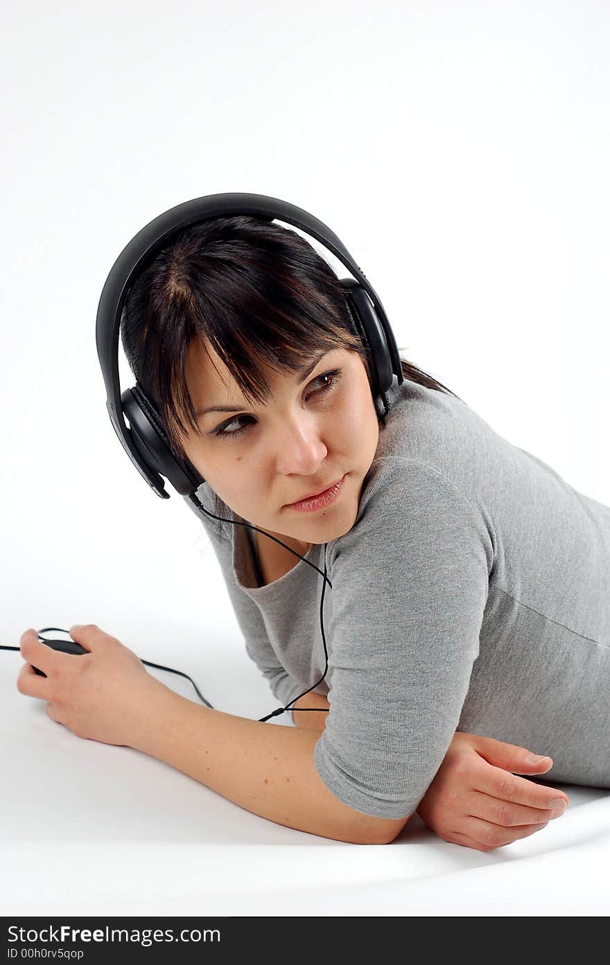 Attractive woman lying with headphones on white background. Attractive woman lying with headphones on white background