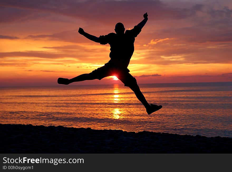 Man jumping on the beach at sunrise. Man jumping on the beach at sunrise