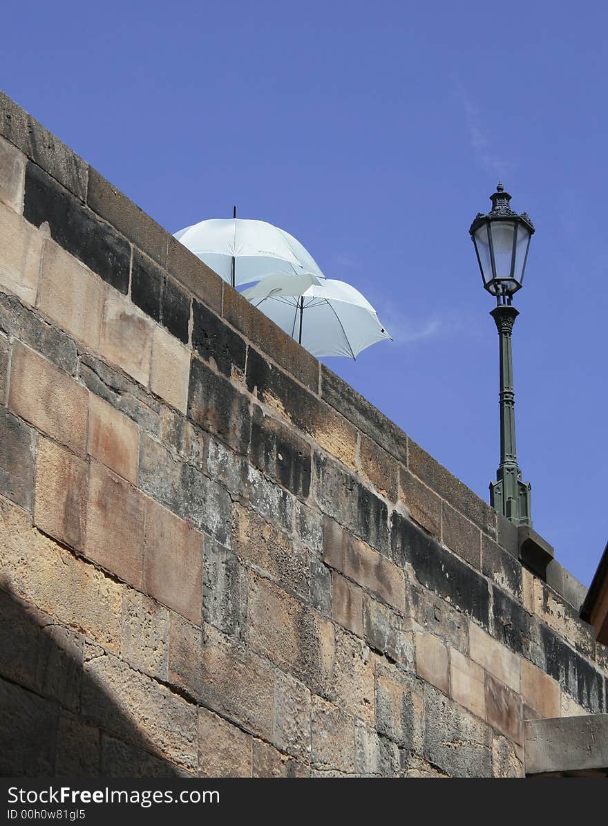 Two parasols on a bridge.