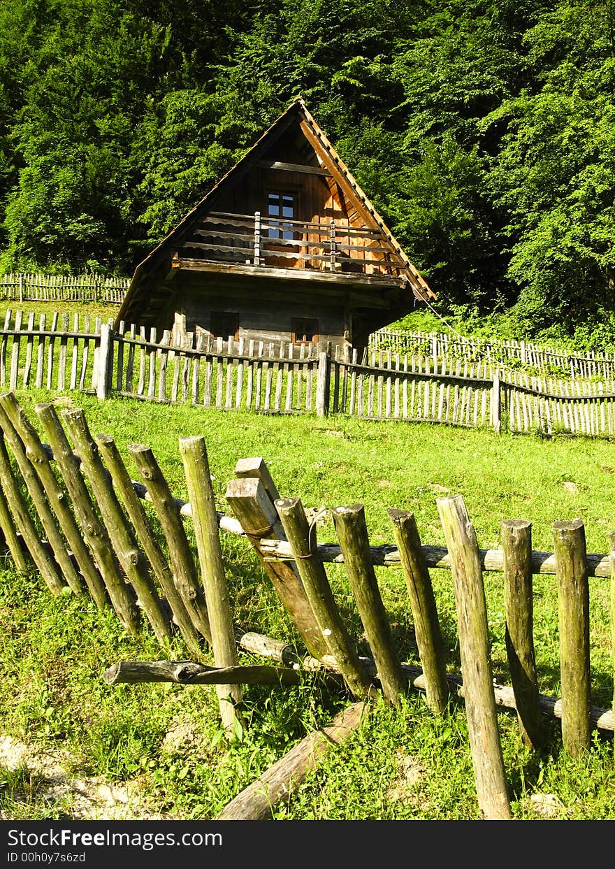 Old classic nice wooden fence and house in the summer meadow