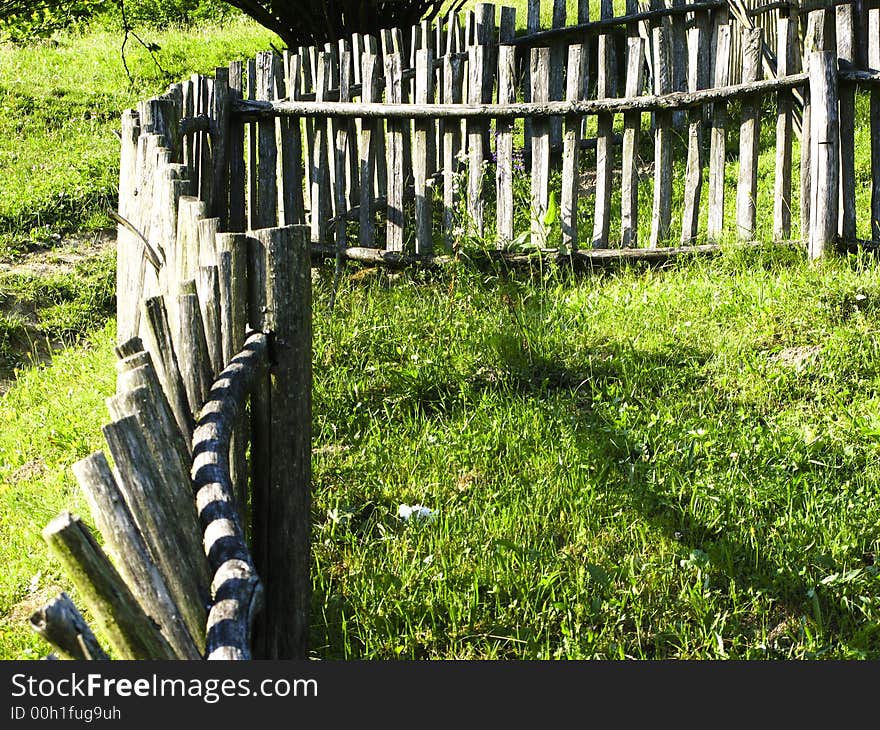 Old classic nice wooden fence in the summer meadow