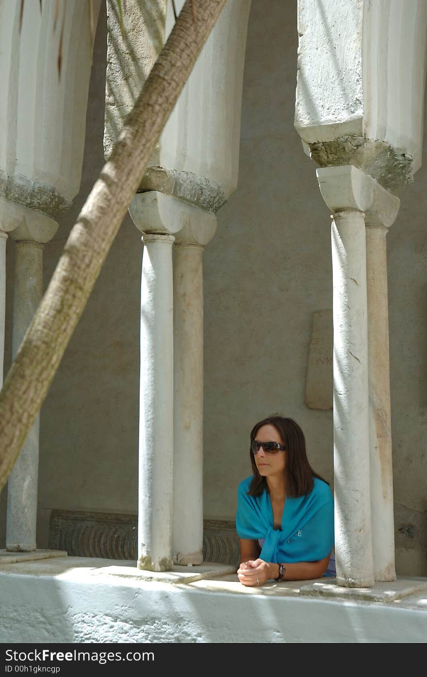 Young woman looking out from underneath arches