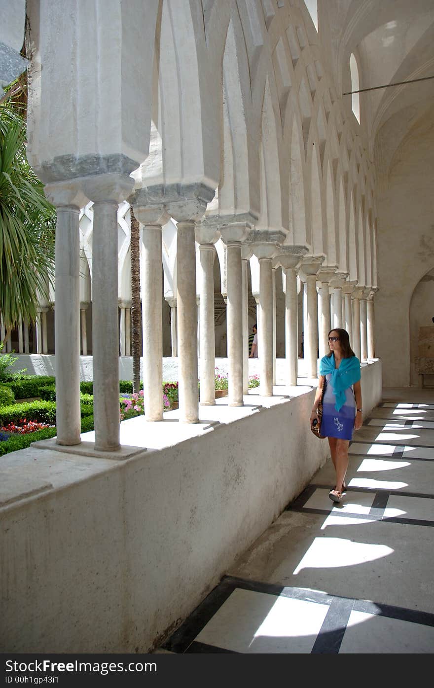 Young woman looking out from underneath arches