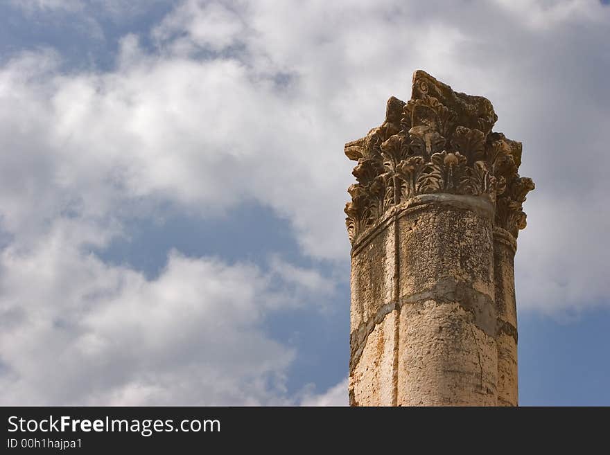 A high harmonous column in ancient port Caesaria on a background of the cloudy sky. A high harmonous column in ancient port Caesaria on a background of the cloudy sky