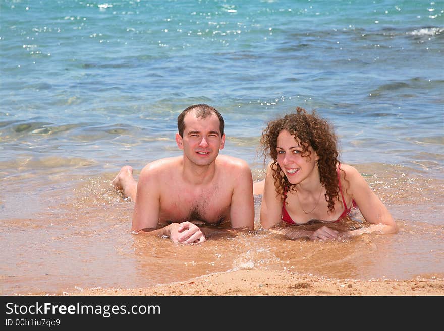 The woman and the man together lay at the sea. The woman and the man together lay at the sea