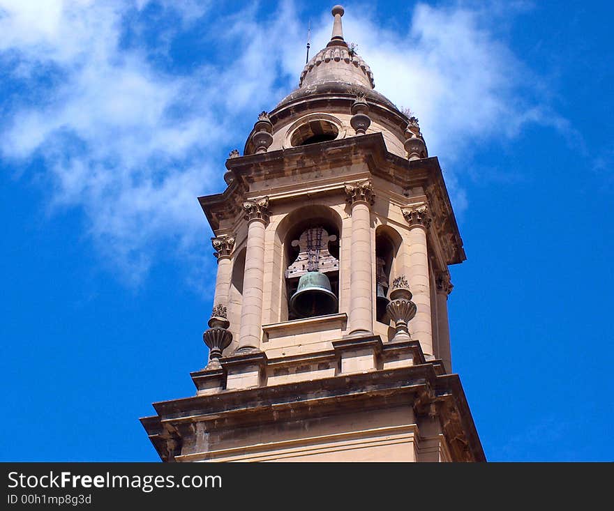 Tall bell tower of church against blue sky dotted with clouds. Tall bell tower of church against blue sky dotted with clouds