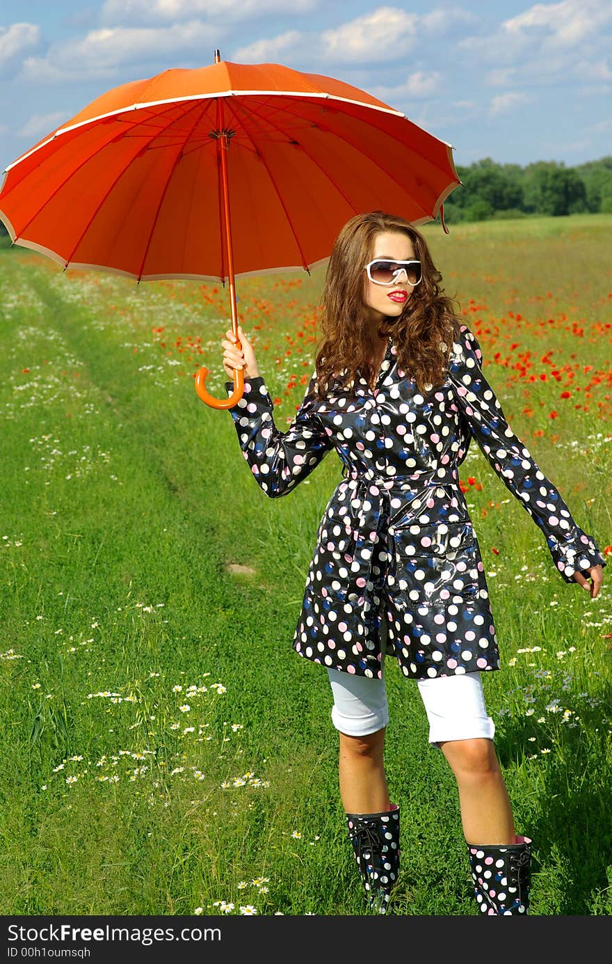 Happy young brunette with orange umbrella