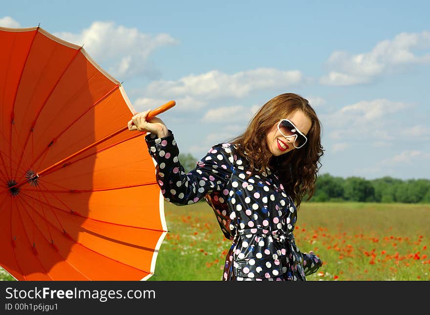 Happy young brunette with orange umbrella