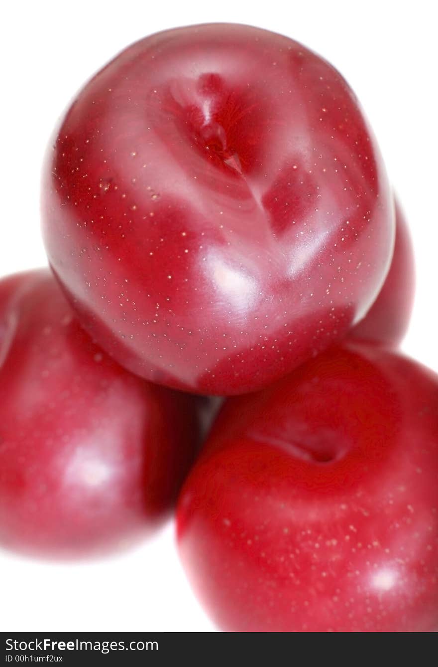 Close-up of stacked organic juicy plums on white background