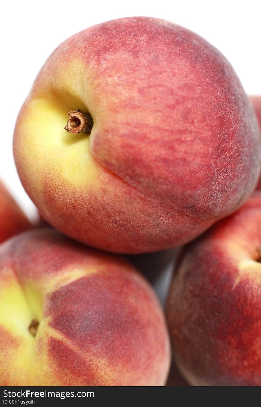 Close-up of stacked organic juicy peaches on white background