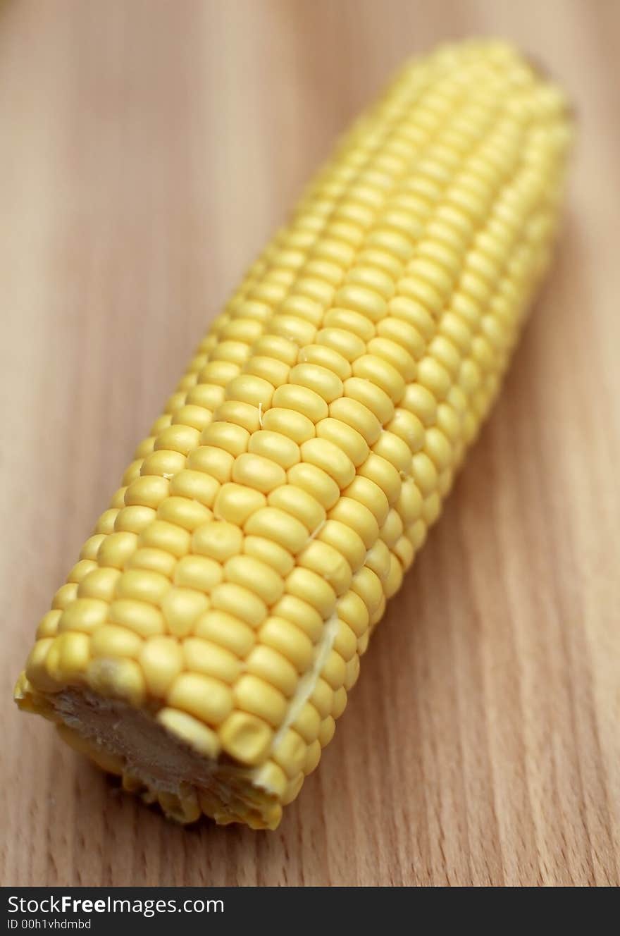 Fresh corn on the cobb on chopping board