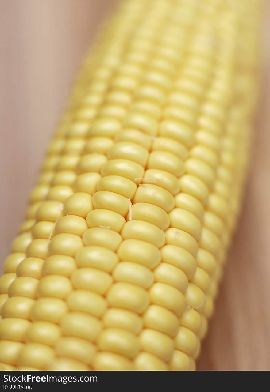 Fresh corn on the cobb on chopping board