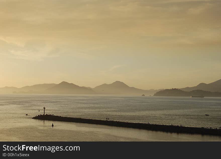 Lighthouse and mall in orange sunset light in Manzanillo, Mexico.