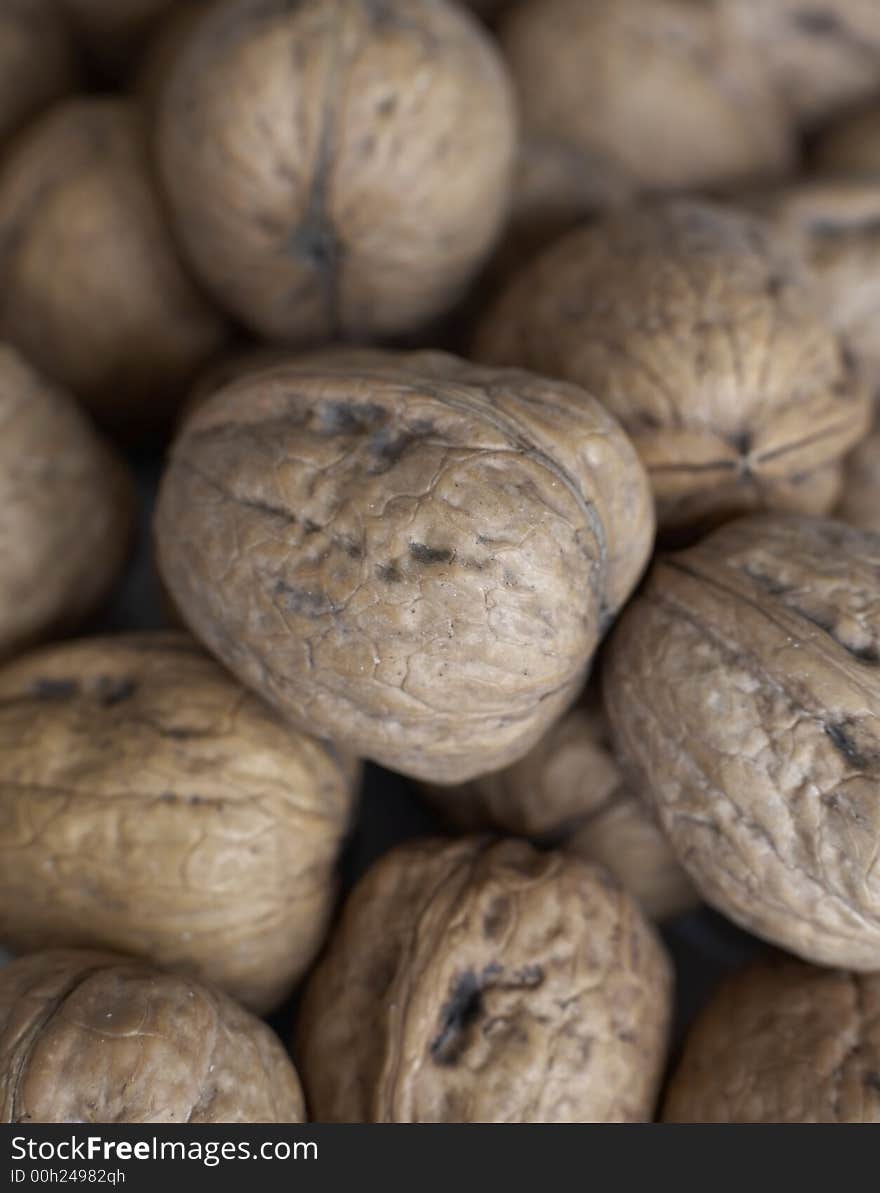 Close up of a pile of walnuts in the shells