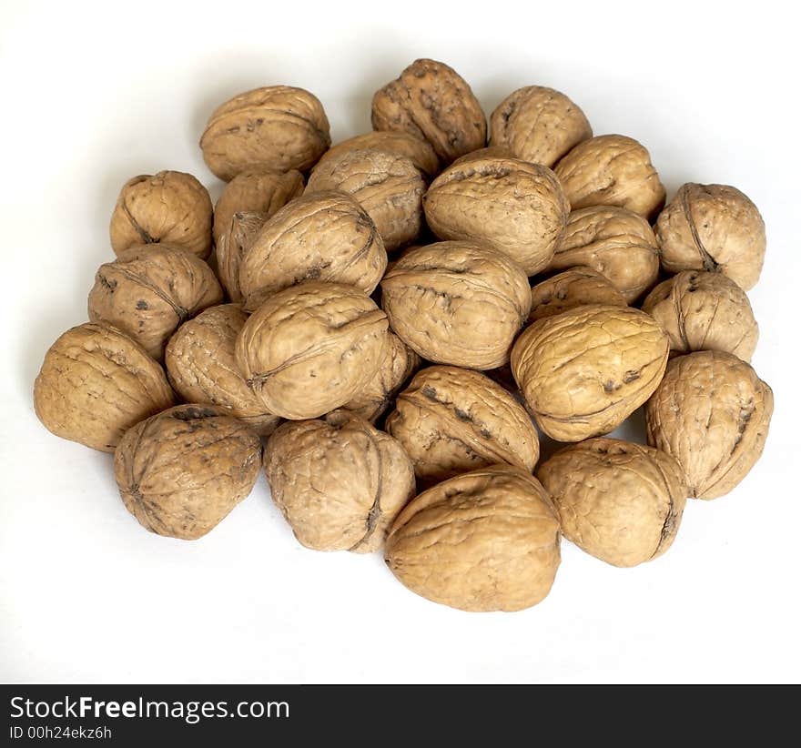 Close up of a pile of walnuts in the shells