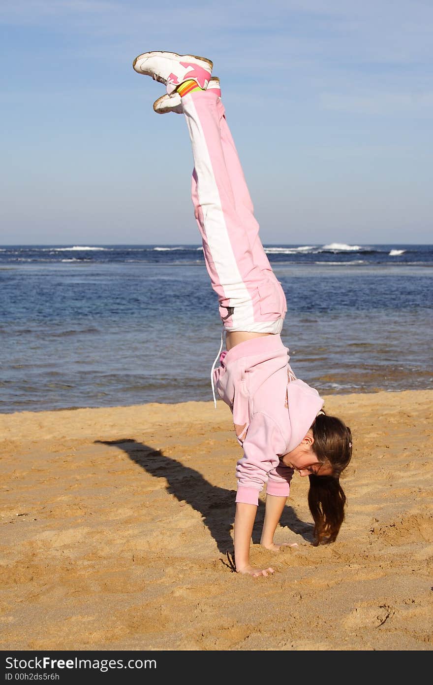 Girl on beach doing a handstand