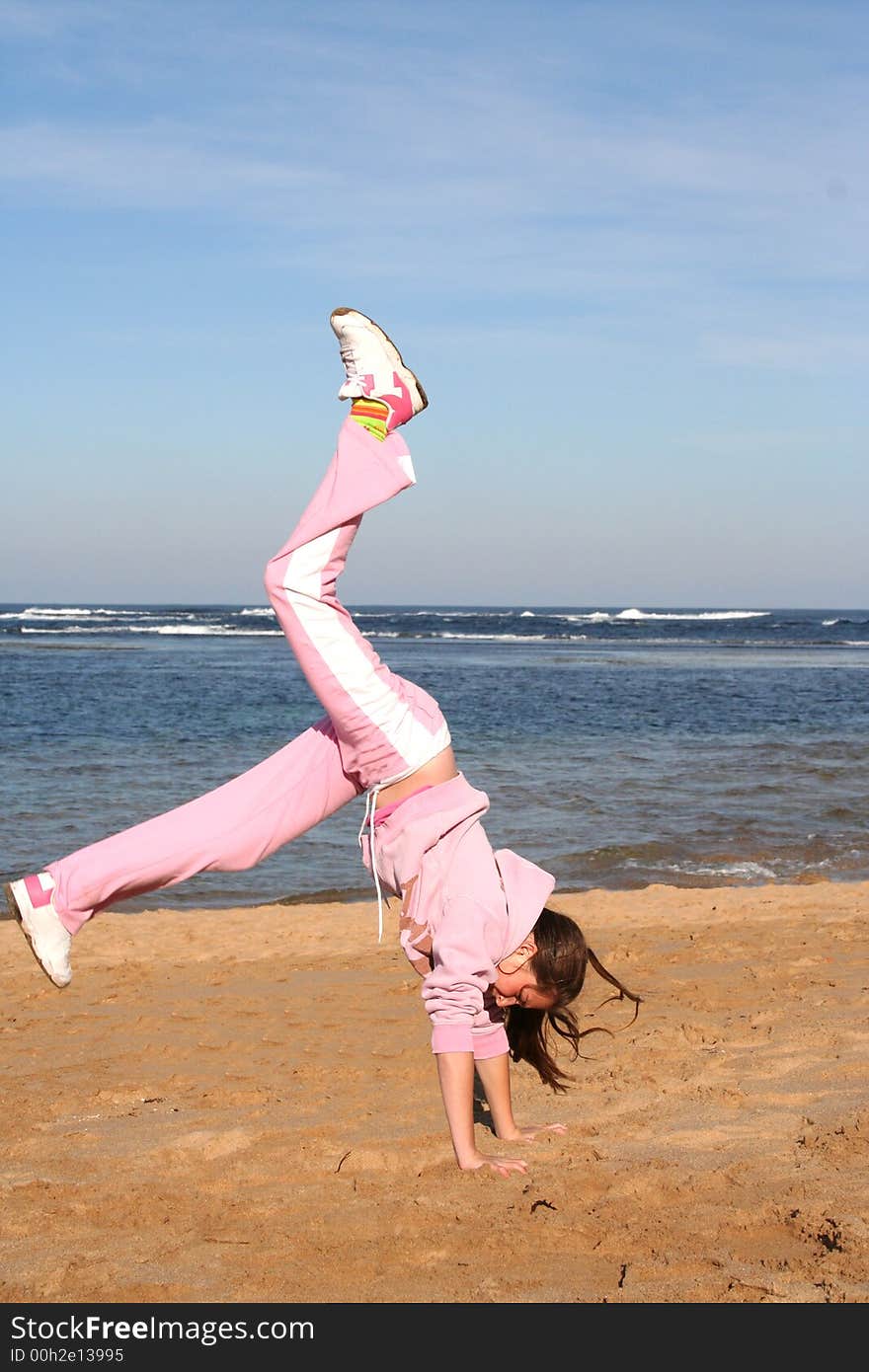 Girl on beach doing a handstand