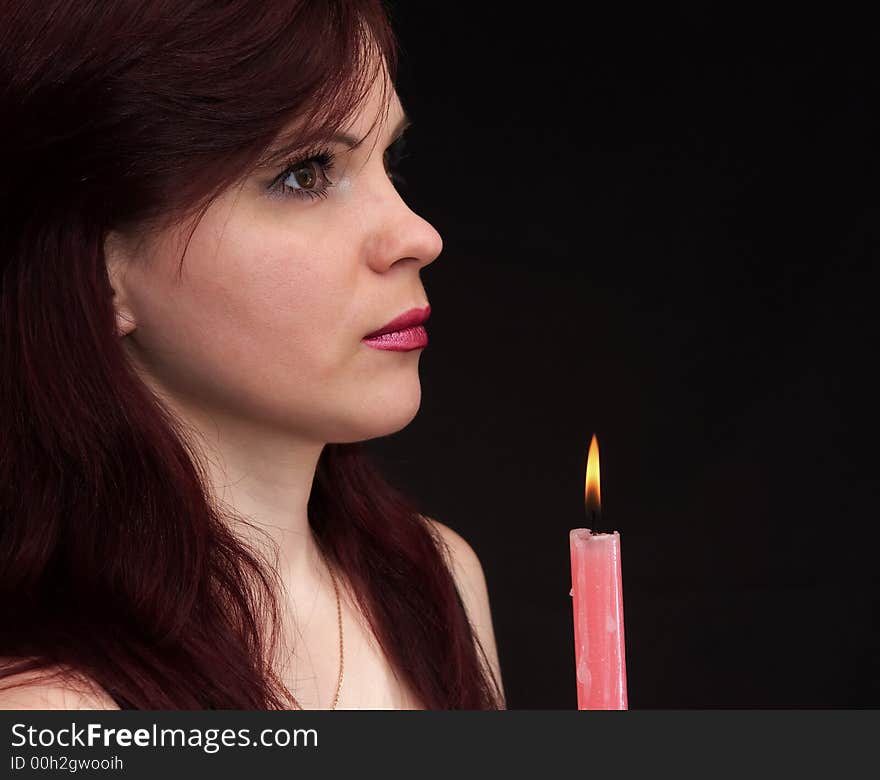 Girl and burning red candle. Girl and burning red candle