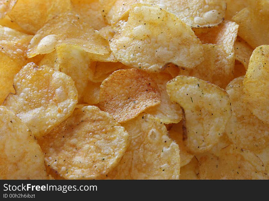 Golden potato chips on background