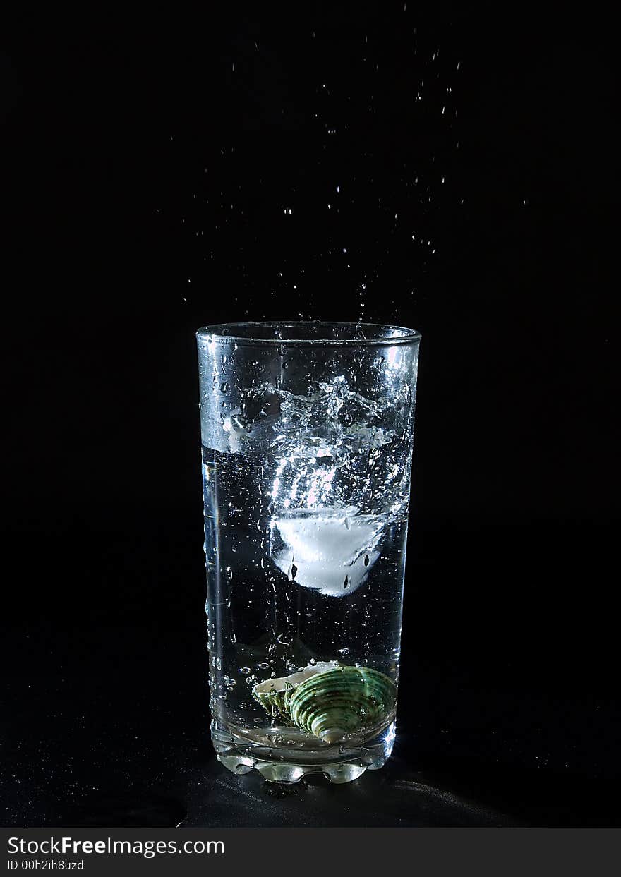 Ice splashing water in the glass